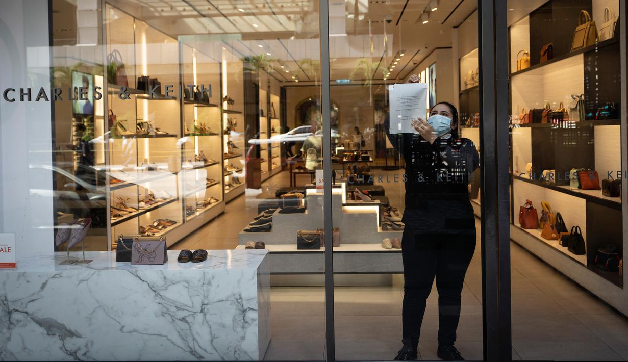 Seorang staf toko ritel bersiap untuk membuka kembali di Kuala Lumpur, Malaysia, Senin, (4/5/2020). Banyak sektor bisnis dibuka kembali pada Senin di beberapa bagian Malaysia sejak penguncian sebagian virus dimulai 18 Maret. (AP/Vincent Thian)