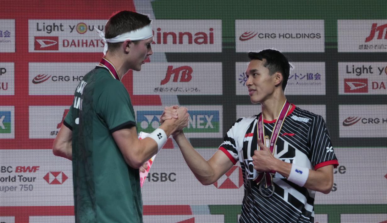 Pebulu tangkis Denmark Viktor Axelsen dan pebulu tangkis tunggal putra Indonesia Jonatan Christie berjabat tangan saat penyerahan medali Japan Open 2023 di Tokyo, Minggu (30/7/2023). (AP Photo/Hiro Komae)