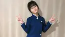 Atasan yang dikenakan Bilqis memiliki desain asimetris dengan kancing emas yang memberikan sentuhan elegan. Kerah putih tinggi semakin memperkuat kesan khas Jepang, dipadukan dengan celana panjang biru tua yang serasi. Rambut pendek berponi serta kacamata yang dikenakannya membuatnya semakin mirip karakter dalam anime atau drama Jepang. (Liputan6.com/IG/@ayutingting92)