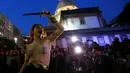 Seorang wanita dari sebuah kelompok seni bertelanjang dada saat berunjuk rasa memprotes maraknya pemerkosaan dan kekerasan seksual di pusat kota Rio de Janeiro, Brasil, Rabu (1/6). (REUTERS/Ricardo Moraes)