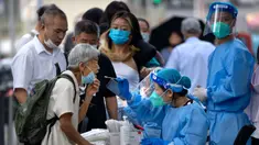 Seorang pekerja yang mengenakan pakaian pelindung menyeka tenggorokan seorang wanita untuk tes COVID-19 di fasilitas pengujian virus corona di Beijing, China, Jumat (12/8/2022). Beberapa kota di China yang dilanda COVID-19 dari timur ke barat negara itu memberlakukan pembatasan dan lockdown baru untuk menahan gejolak yang sekali lagi mengancam akan mengganggu ekonomi lokal. (AP Photo/Mark Schiefelbein)
