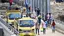 Diketahui, hingga kini, pemerintah melalui Kementerian Pekerjaan Umum dan Perumahan Rakyat (PUPR) bersama TNI/Polri serta warga setempat terus bergerak cepat membangun jembatan bailey sebagai solusi darurat. Tampak dalam foto, warga menyeberangi sungai di jembatan yang baru dibangun yang menghubungkan Aceh dan Provinsi Sumatera Utara setelah hancur akibat banjir bandang di Sungai Peusangan, Distrik Bireuen, Provinsi Aceh, Selasa 9 Desember 2025. (CHAIDEER MAHYUDDIN/AFP)