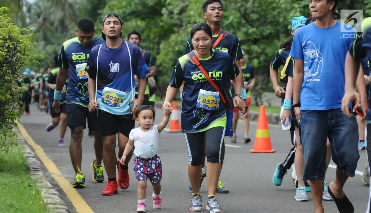 Pelari membawa anaknya saat mengikuti lomba Pertamina Eco Run 2017 di Pantai Karnaval Ancol, Jakarta, Sabtu (16/12). Pertamina Eco Run 2017 diikuti ribuan pelari dari tiga kategori, yakni master, umum dan pelajar. (Liputan6.com/Helmi Fithriansyah)