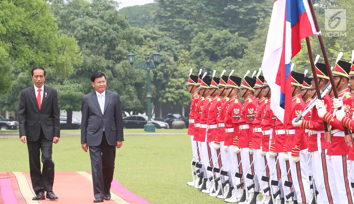 Presiden Joko Widodo (Jokowi) mendampingi PM Republik Demokratik Rakyat, Laos Thongloun Sisoulith melakukan pemeriksaan pasukan kehormatan pada upacara kenegaraan di Istana Kepresidenan Bogor, Jawa Barat, Kamis (12/10). (Liputan6.com/Angga Yuniar)