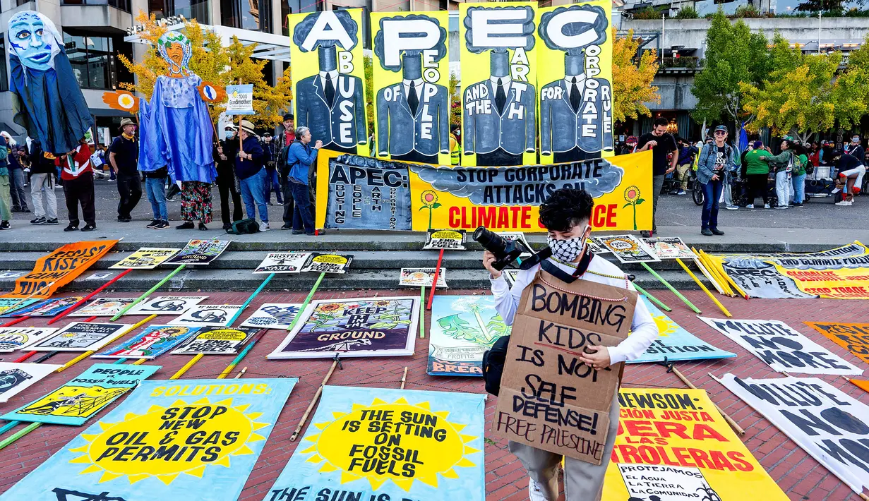 Spanduk dan poster-poster menentang forum Kerjasama Ekonomi Asia-Pasifik (APEC) ditunjukkan seraya menyerukan perubahan ekonomi dan isu lingkungan hidup (AP Photo/Noah Berger)