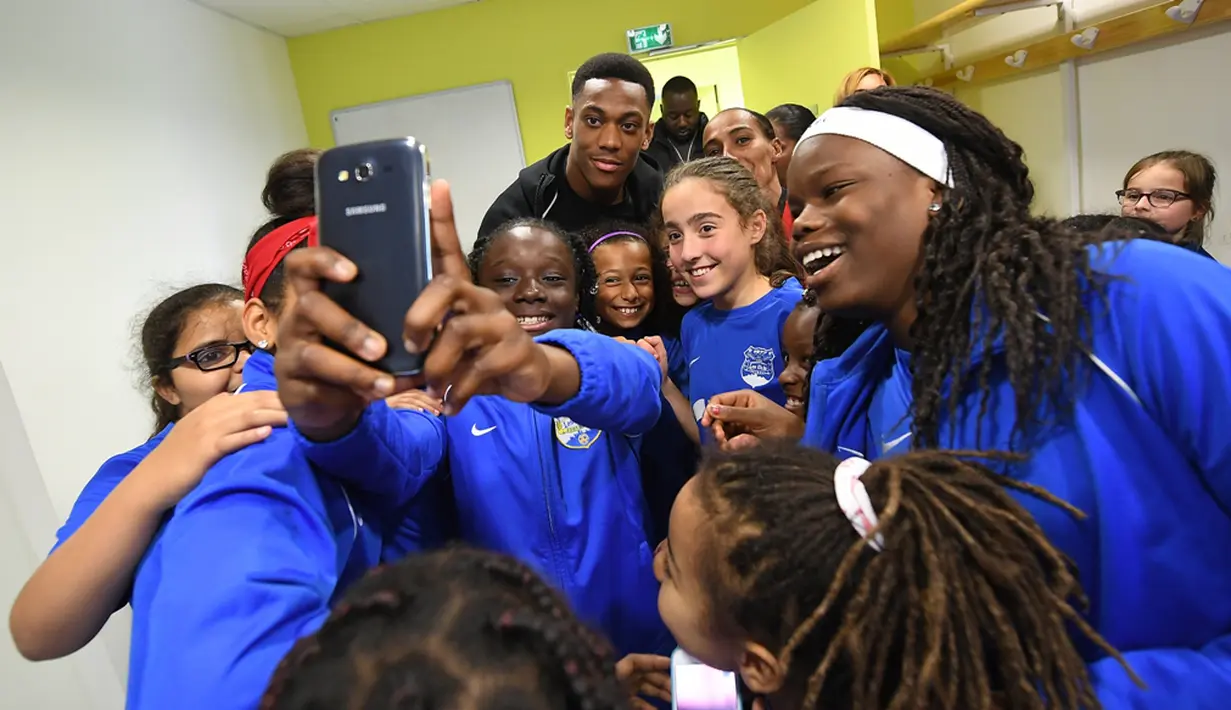 Pemain Timnas Prancis, Anthony Martial, berfoto bersama pemain muda Les Ulis, (23/5/2016). (AFP/Franck Fife) 