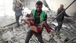 Petugas mengevakuasi seorang anak yang terluka akibat serangan udara di kawasan Douma yang dikuasai para pemberontak di Damaskus, Suriah (7/11). Serangan ini memakan korban warga sipil yang sebagian besar anak-anak. (Reuters/Bassam Khabieh)