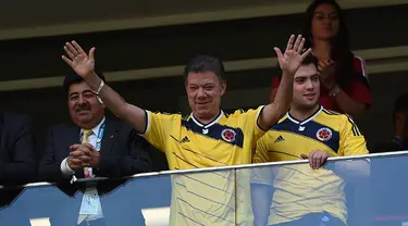 Presiden Kolombia, Juan Manuel Santos (tengah), menyaksikan langsung laga Los Cafeteros kontra Pantai Gading di Stadion National Mane Garrincha, Brasil, (19/6/2014). (AFP PHOTO/Eitan Abramovich)