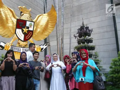 Sejumlah umat muslim foto bersama di depan Garuda Pancasila di Gereja Katedral, Jakarta, Jumat (1/6). Kegiatan tersebut digelar komunitas Kerja Bakti Demi Negeri sambil buka puasa bersama. (Liputan6.com/Arya Manggala)