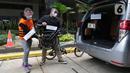 Tersangka Harry Sidabuke (kiri) bersama perantara anggota Komisi II DPR Ihsan Yunus, Agustri Yogasmara mengangkat sepeda Brompton saat rekonstruksi perkara dugaan korupsi pengadaan bantuan sosial penanganan COVID-19 di gedung KPK, Jakarta, Rabu (10/2/2021). (Liputan6.com/Helmi Fithriansyah)