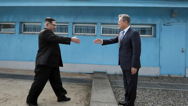 27 April 2018 pemimpin Korea Utara Kim Jong Un (kiri) , bersiap berjabat tangan dengan Presiden Korea Selatan Moon Jae in (kanan) di atas garis demarkasi militer di desa perbatasan Panmunjom di Zona Demiliterisasi. (AP/Arsip)