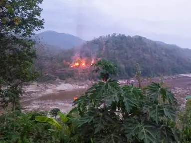 Kebakaran pangkalan militer Myanmar sepanjang tepi Sungai Salween terlihat dari Kota Mae Sam Laep, Provinsi Mae Hong Son, Thailand, Selasa (27/4/2021). Pangkalan militer Myanmar itu diserang dan direbut pemberontak Persatuan Nasional Karen (KNU). (Handout/KAWTHOOLEI TODAY/AFP)