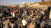 Orang-orang berbelanja hewan kurban di pasar ternak Jumat di Hebron, Tepi Barat, pada 14 Juni 2024. (HAZEM BADER/AFP)