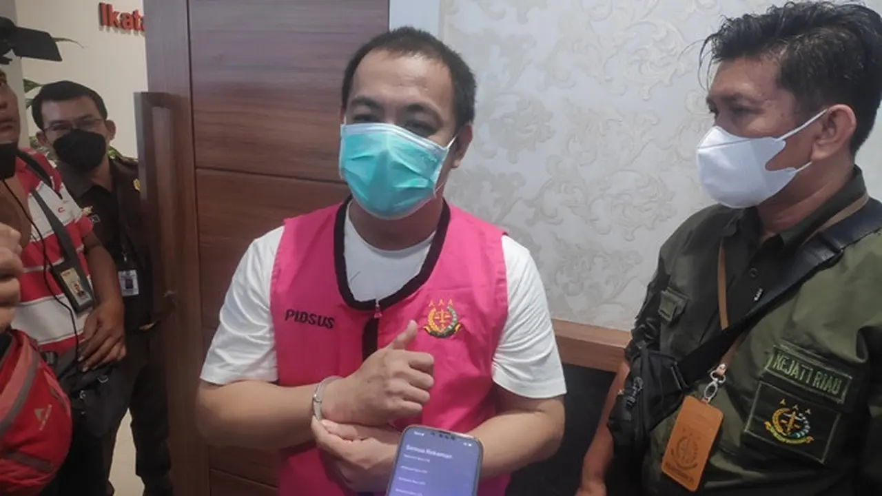 Tersangka pengemplangan pajak di Riau memakai rompi tahanan sebelum ditahan jaksa.