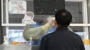 Petugas medis mengambil sampel hidung dari seorang pria di tempat pengujian COVID-19 darurat, Seoul, Korea Selatan, Rabu (24/11/2021). Kasus COVID-19 di Korea Selatan menembus 4.000 dalam sehari untuk pertama kalinya sejak dimulainya pandemi. (AP Photo/Ahn Young-joon)