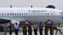 Beberapa petugas mengangkat dua jenazah korban pesawat AirAsia QZ8501 yang sudah berada dalam peti bernomor 001 dan 002 di Lanud TNI AL Juanda, Rabu (31/12/2014). (Liputan6.com/Johan Tallo)
