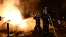 Petugas pemadam kebakaran menyemprotkan air untuk memadamkan tempat sampah yang terbakar di wilayah Mirail, Toulouse, Prancis (17/4). Sejumlah pemuda di kawasan Mirail mengamuk, mereka membakar mobil dan menyerang polisi. (AFP/Remy Gabalda)