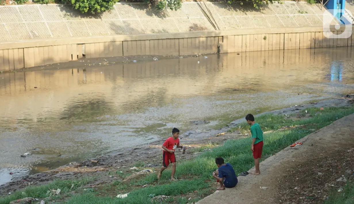 Anak-anak bermain di bantaran Sungai Ciliwung yang mengering, kawasan Kampung Melayu, Jakarta, Jumat (8/11/2019). Curah hujan yang tidak menentu menyebabkan sebagian bantaran Ciliwung masih mengalami kekeringan. (Liputan6.com/Immanuel Antonius)