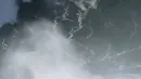 Seorang peselancar keluar dari gelombang selama sesi selancar derek di Praia do Norte atau Pantai Utara di Nazare, Portugal (29/10/2020). Gelombang besar, yang ditimbulkan oleh Badai Epsilon di Atlantik Utara, mencapai Portugis pantai barat menarik peselancar ombak besar ke Nazare. (AP Photo/Pedro R