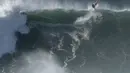 Seorang peselancar keluar dari gelombang selama sesi selancar derek di Praia do Norte atau Pantai Utara di Nazare, Portugal (29/10/2020). Gelombang besar, yang ditimbulkan oleh Badai Epsilon di Atlantik Utara, mencapai Portugis pantai barat menarik peselancar ombak besar ke Nazare. (AP Photo/Pedro R