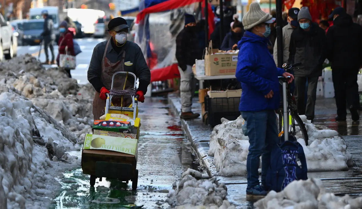 Orang-orang yang mengenakan masker bekerja dan berjalan di kawasan Chinatown di New York City, 5 Februari 2021. Tahun Baru Imlek akan jatuh Jumat depan, 12 Februari, dan itu harusnya menjadi waktu tersibuk untuk Chinatown, tetapi tidak pada tahun 2021 saat pandemi COVID-19 mewabah (Angela Weiss/AFP)