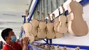 Pekerja menata biola di sebuah bengkel kerja di Queshan, Provinsi Henan, China, Rabu (20/5/2020). Kawasan industri penghasil alat musik tersebut mampu memproduksi 30.000 biola dan selo setiap tahun. (Xinhua/Zhu Xiang)