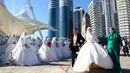 Pasangan yang baru menikah menghadiri perayaan Rusia City Day di Grozny, Rusia, (5/10). Sebanyak 199 pasangan menikah di Taman Bunga Grozny pada perayaan tersebut. (AP Photo / Musa Sadulayev)