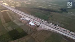 Foto udara antrean kendaraan pemudik di jalur tol fungsional GT Kertasari, Tegal, Minggu (10/6). Di pintu tol tersebut, ada 13 gardu yang dibuka untuk melayani pembayaran terakhir tarif tol dari Jakarta hingga Brebes Timur. (Liputan6.com/Arya Manggala)