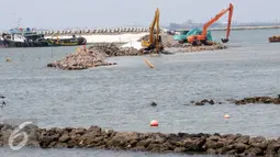 Sejumlah alat berat melakukan penimbunan material padat di Teluk Utara Jakarta, Rabu (16/3). Meskipun menuai pro dan kontra, proyek tersebut terus berjalan dan rencananya akan rampung pada akhir tahun 2018. (Liputan6.com/Helmi Afandi)