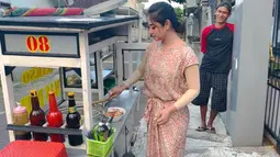 Pedangdut Dewi Perssik sedang membuat sendiri bakso yang dijual di depan rumah orangtuanya. Dewi Perssik memang sedang berada di kampung halamannya di Jember. (Youtube/Dewi Perssik)