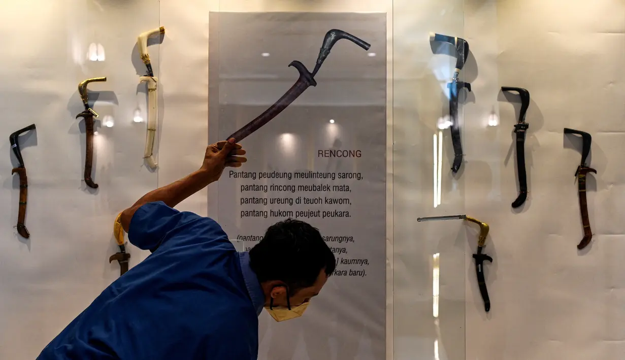 Seorang pekerja membersihkan etalase yang memajang rencong jelang pameran persenjataan tradisional di Museum Aceh, Banda Aceh, Aceh, Jumat (15/10/2021). Museum Aceh menggelar Pameran Senjata 2021 dengan mengangkat tema “Semangat, Simbol, dan Identitas". (CHAIDEER MAHYUDDIN/AFP)