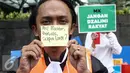 Seorang peserta aksi menunjukan tulisan nama tokoh yang terlibat kasus suap saat Car Free Day dikawasan Bunderan HI, Jakarta, Minggu (12/2). Aksi tersebut untuk menanggapi kasus Hakim Mahkamah Konstitusi, Patrialis Akbar. (Liputan6.com/Faizal Fanani)