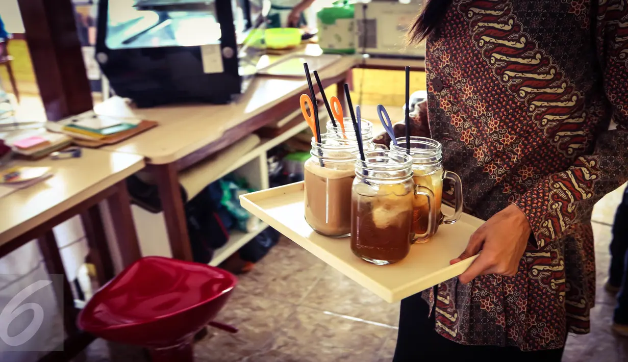 Pramusaji yang merupakan penyandang tunarungu menyajikan minuman kepada pelanggan di kafe Finger Talk, Pamulang, Tangsel, Sabtu (20/2). Dengan ramah dan cekatan, sejumlah penyandang tunarungu akan menjamu para pengunjung. (Liputan6.com/Fery Pradolo)