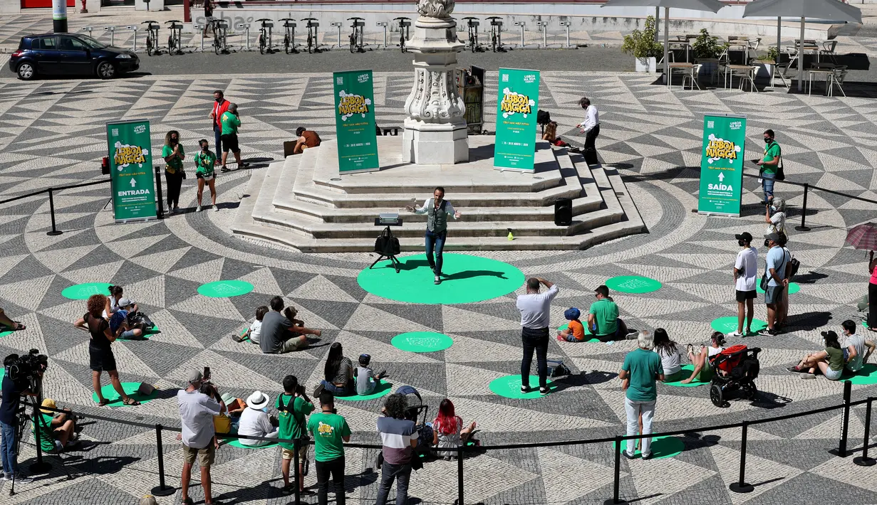 Para penonton menerapkan jaga jarak fisik saat menyaksikan pertunjukan sulap dalam Festival Dunia Sulap Jalanan Lisbon di Lisbon, Portugal (25/8/2020). Festival Dunia Sulap Jalanan Lisbon kedelapan dimulai pada Selasa (25/8). (Xinhua/Pedro Fiuza)
