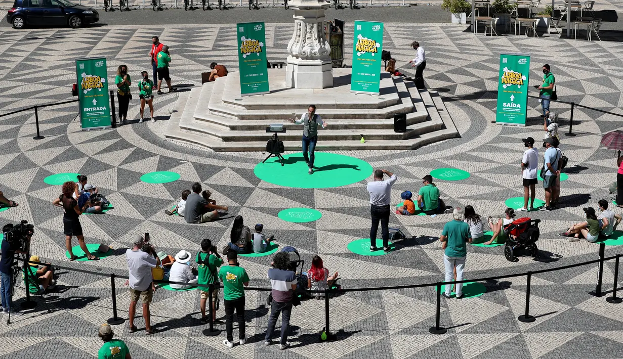 Para penonton menerapkan jaga jarak fisik saat menyaksikan pertunjukan sulap dalam Festival Dunia Sulap Jalanan Lisbon di Lisbon, Portugal (25/8/2020). Festival Dunia Sulap Jalanan Lisbon kedelapan dimulai pada Selasa (25/8). (Xinhua/Pedro Fiuza)