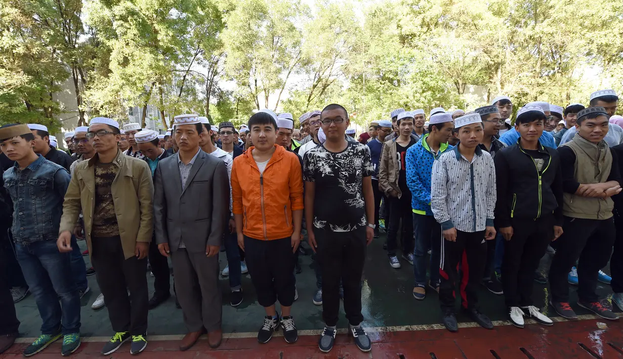 Sejumlah mahasiswa berdiri mengikuti kegiatan di kampus Institut Agama Islam Ningxia di Yinchuan, Ningxia provinsi utara China (22/9/2015). Kampus ini memiliki slogan "Cinta negara, cinta agama" yang terpampang di pintu masuk. (AFP PHOTO/GOH CHAI HIN)