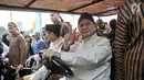 Pasangan capres dan cawapres Prabowo Subianto-Sandiaga Uno menaiki mobil golf sambil menunjukkan salam dua jari saat mengikuti pawai Deklarasi Kampanye Damai di Monas, Minggu (23/9). (Merdeka.com/Iqbal Nugroho)