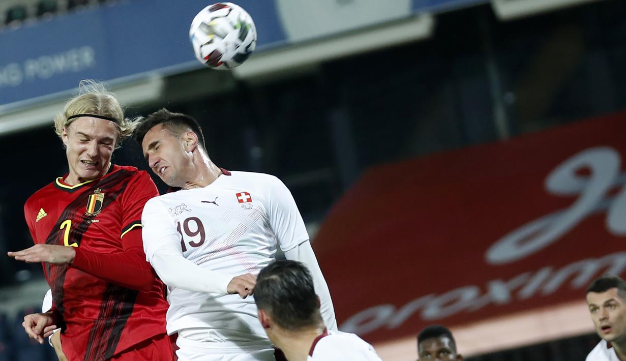 Pemain Belgia, Sebastiaan Bornauw (kiri), berduel udara dengan pemain Swiss, Haris Sferovic, dalam pertandingan uji coba Internasional di Stadion King Power, Belgia, Kamis (12/11/2020) dini hari WIB. Belgia mengalahkan Swiss 2-1. (AP Photo/Francisco Seco).
