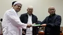 Habib Rizieq Shihab bersama sejumlah tokoh GNPF MUI menyerahkan laporan kepada Wakil Ketua Komisi III DPR Desmond J Mahesa (kanan) saat mendatangi Komisi III di Kompleks Parlemen Senayan, Jakarta, Selasa (17/1). (Liputan6.com/JohanTallo)