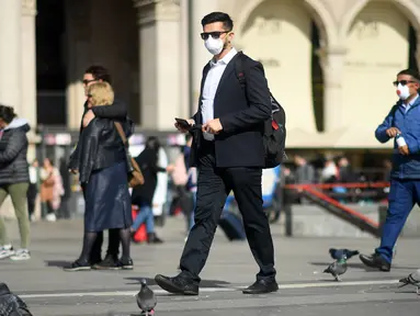 Warga memakai masker berjalan di Milan, Italia (24/2/2020). Kepala Departemen Perlindungan Sipil sekaligus Komisaris Luar Biasa untuk Darurat Coronavirus, Angelo Borrelli mengatakan enam orang meninggal dan 222 lainnya teruji positif infeksi COVID-19 di Italia. (Xinhua/Daniele Mascolo)