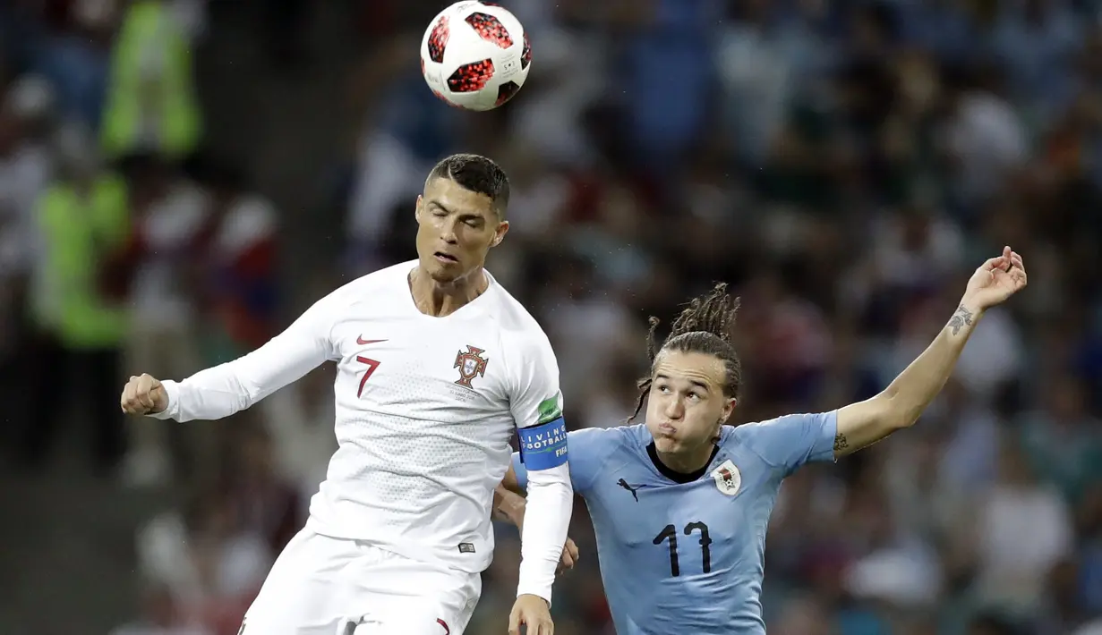 Duel pemain Portugal, Cristiano Ronaldo (kiri) dan pemain Uruguay, Diego Laxalt pada laga 16 besar Piala Dunia 2018 di Fisht Stadium, Sochi, Rusia, (30/6/2018). Portugal kalah 1-2. (AP/Andrew Medichini)
