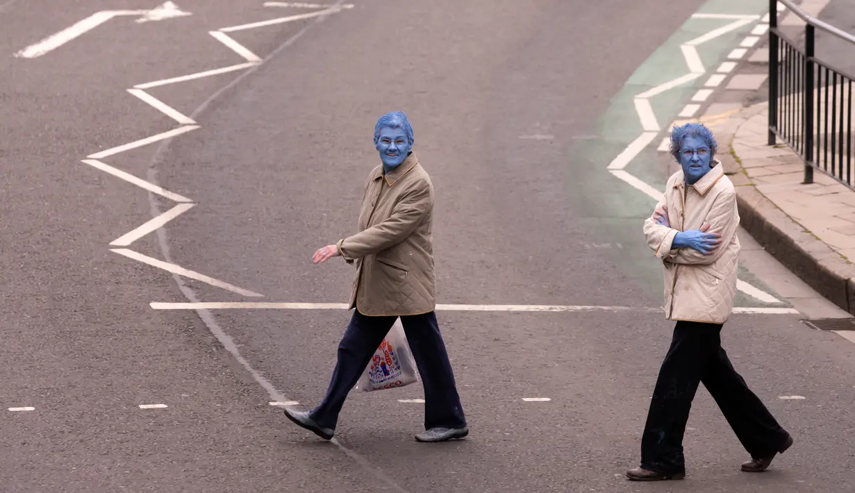 Dua model mengenakan pakaiannya kembali seusai mengikuti sesi foto saat menjadi model sebuah seni berjudul "Sea of Hull" karya Spencer Tunick asal Amerika Serikat di pusat Kota Hull, Inggris, Sabtu (9/7). (AFP Photo/Jon Super)