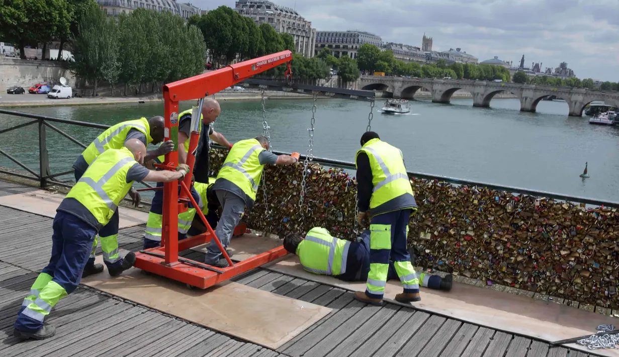 Sejumlah petugas saat memindahkan ribuan gembok cinta, dari sisi pembatas pagar Jembatan Pont des Arts di atas Sungai Seine, Paris, Perancis, Senin (1/6/2015). (REUTERS/Philippe Wojazer)