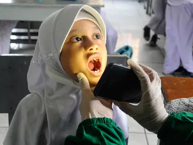 Paramedis Puskesmas Cinere memeriksa kesehatan gigi murid kelas III di SDI Al Hidayah, Cinere, depok, Senin (12/9/20222). Selain pemeriksaan gigi, telinga, dan kuku yang dilakukan periodik 6 bulan sekali  juga dilakukan penyuluhan kesehatan dan pemberian obat cacing kepada anak-anak. (merdeka.com/Arie Basuki)