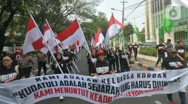 Ratusan orang melakukan aksi berjalan kaki sambal membawa poster dan bendera dari kantor Dewan Pimpinan Pusat (DPP) Partai Demokrasi Indonesia Perjuangan (PDIP) menuju gedung Komisi Nasional Hak Asasi Manusia (Komnas HAM), Jakarta, Jumat (26/7/2024). (merdeka.com/Imam Buhori)