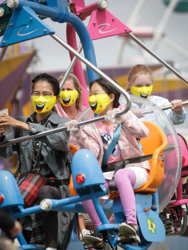 Para pengunjung yang mengenakan masker bersenang-senang menaiki wahana di Playland Amusement Park, di Vancouver, British Columbia, Kanada, pada 10 Juli 2020. Playland Amusement Park dibuka kembali untuk umum pada Jumat (10/7), dengan langkah-langkah protokol kesehatan. (Xihua/Liang Sen)