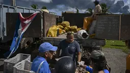 Warga Kuba membeli makanan di pasar pertanian saat terjadi kebakaran hebat di depot bahan bakar di Matanzas, Kuba (7/8/2022). Kuba meminta bantuan Sabtu (7/7) untuk mengatasi kebakaran besar yang menyebabkan 77 orang terluka dan 17 petugas pemadam kebakaran hilang. Sekitar 800 orang telah dievakuasi dari daerah tersebut. (AFP/Yamil Lage)