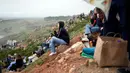 Penggemar selancar duduk di sepanjang tebing untuk menyaksikan para peselancar menaiki ombak selama turnamen selancar Nazare Big Wave Challenge. (AP Photo/Armando Franca)
