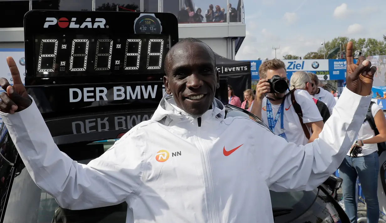 Pelari Kenya, Eliud Kipchoge tersenyum usai memenangkan Berlin Marathon ke-45 di Berlin, Jerman, Minggu (16/9). Kipchoge memecahkan rekor lari marathon dunia dengan menorehkan waktu 2 jam 1 menit 39 detik. (AP Photo/Markus Schreiber)