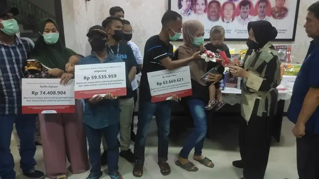 Menteri Sosial Tri Rismaharini menyerahkan pesawat mainan kepada balita penderita jantung bocor.